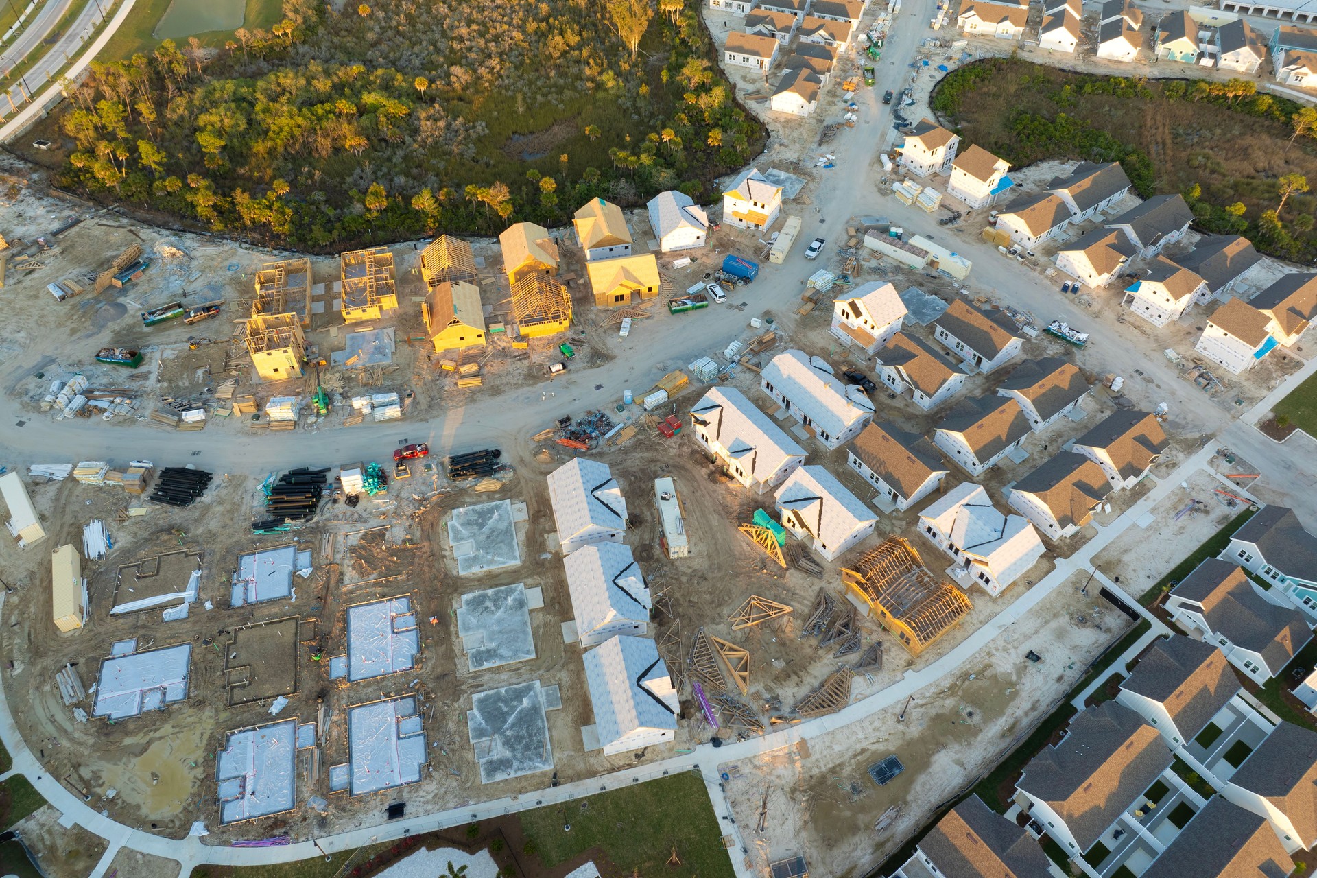 Aerial view of unfinished wooden frames of affordable houses under construction. Development of residential housing in American suburbs. Real estate market in the USA